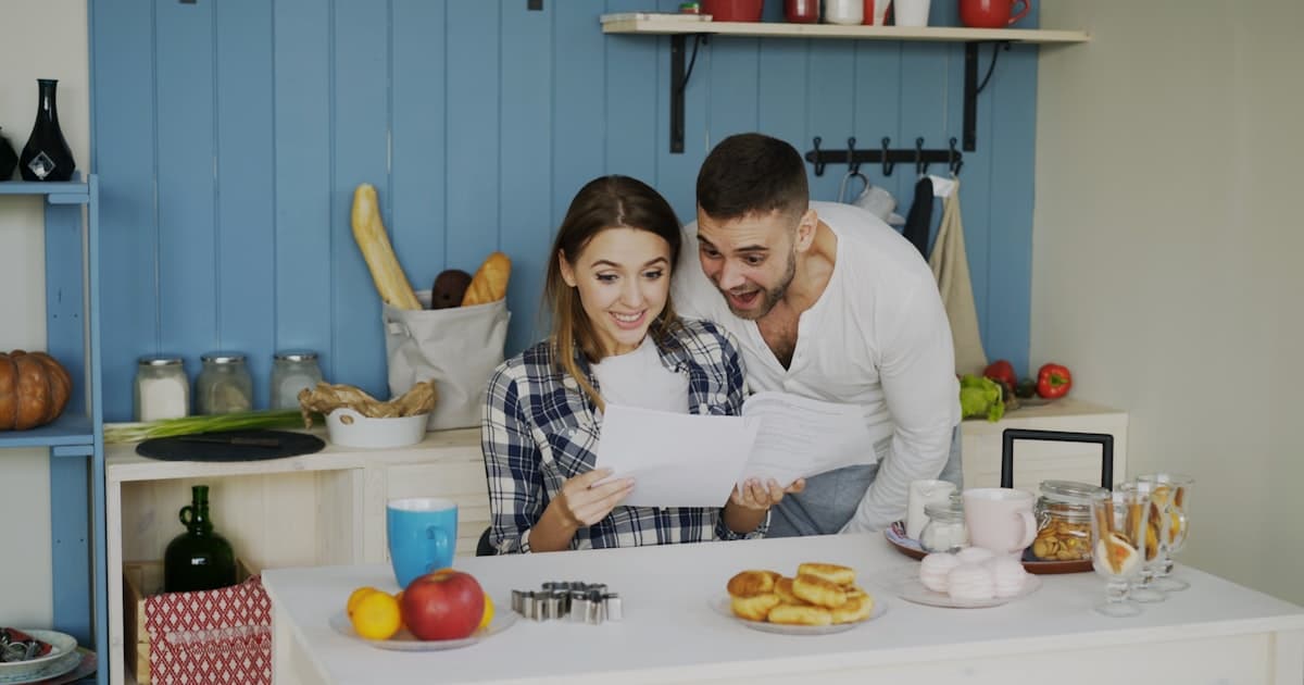 Couple looking at papers together at a bright kitchen table