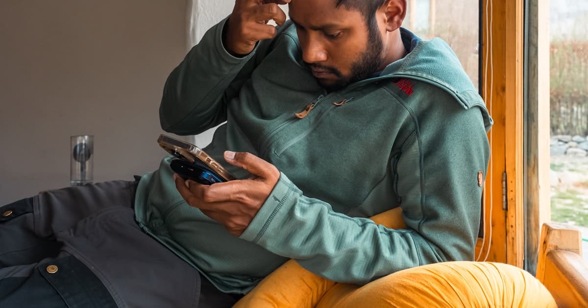 Man looking at his phone with a puzzled expression, checking his account balance
