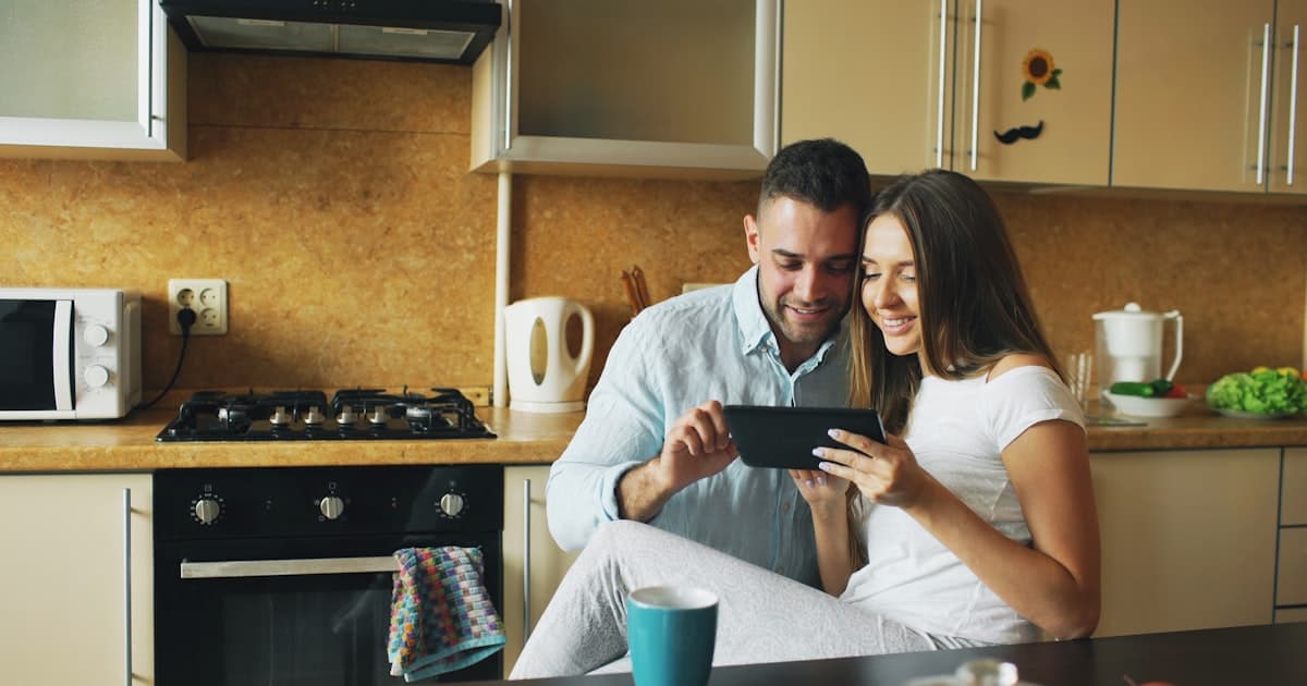 Couple looking at a tablet together in a kitchen