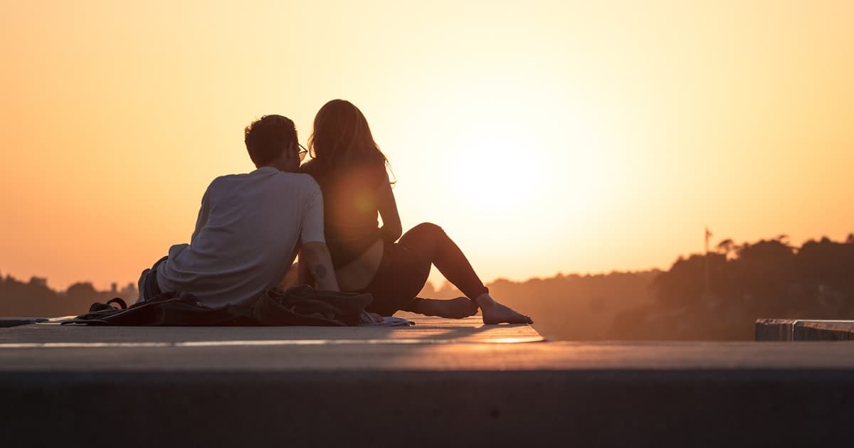 Couple sitting near trees during golden hour