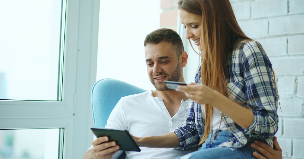 Couple looking at a tablet together, reviewing finances at home